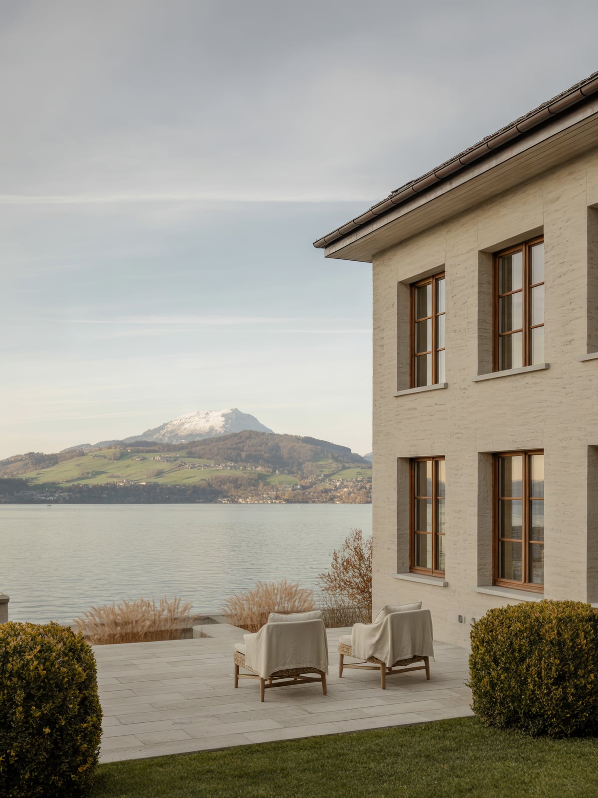 Zeitgenössische Kalksteinvilla mit Terrasse über dem Zugersee im Herbstlicht
